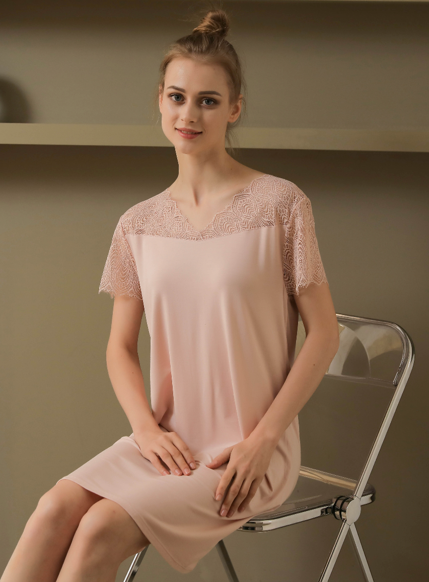 Sitting view of a viscose night gown with pretty lace details from a leading pajama manufacturer, featuring a pink dress with delicate lace trim on the neckline and sleeves, ideal for a stylish and comfortable sleepwear experience. Crafted by a top sleepwear factory