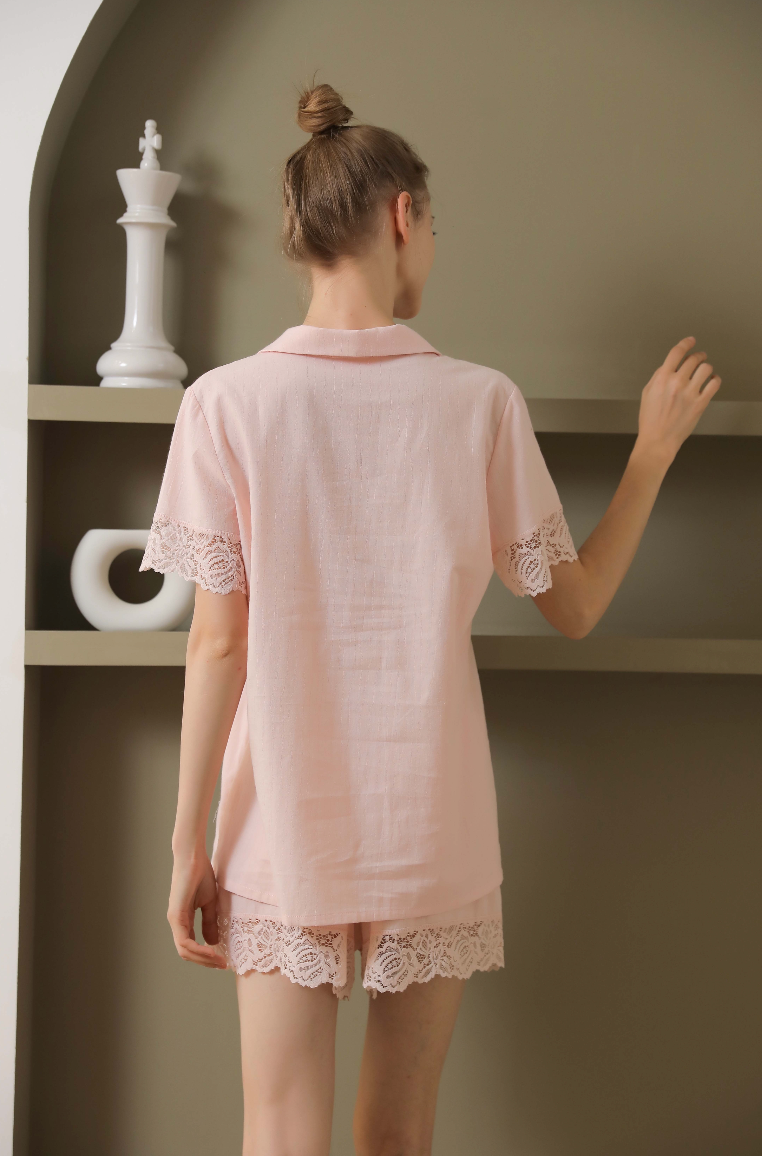 Back view of a cotton pajamas set with lace details from a leading pajama manufacturer, featuring a pink short-sleeve button-up top and matching shorts with delicate lace trim, ideal for a comfortable and elegant sleepwear look. Crafted by a top sleepwear factory